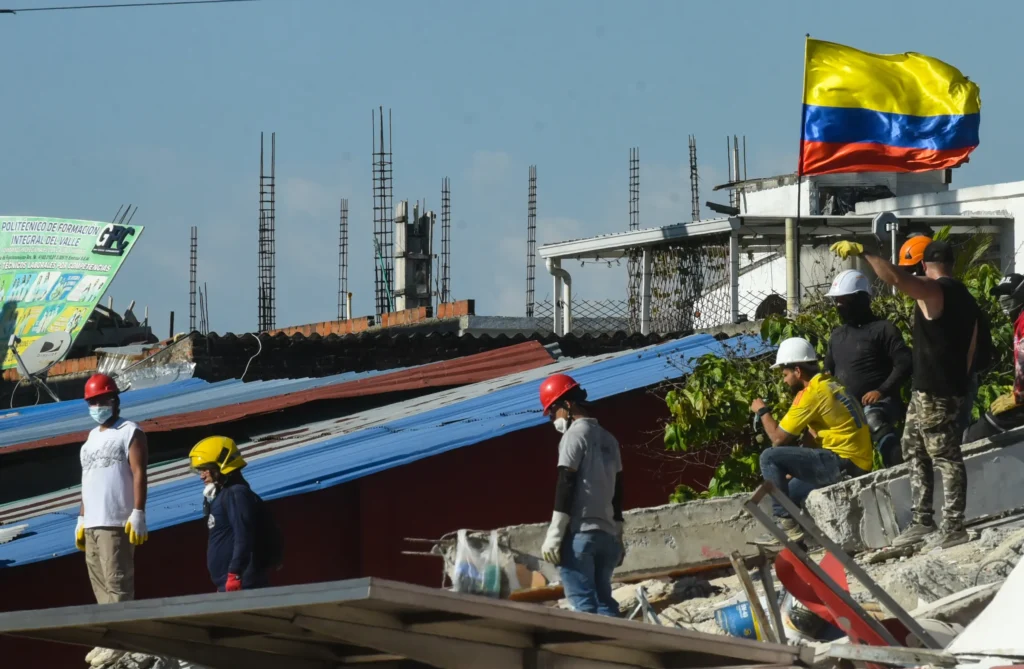 Several people remove debris from the El Molino Hotel and Motel at Carrera 39 and the highway following the magnitude 7.4 earthquake in Cali, Colombia. Photo: Alejandro Meléndez