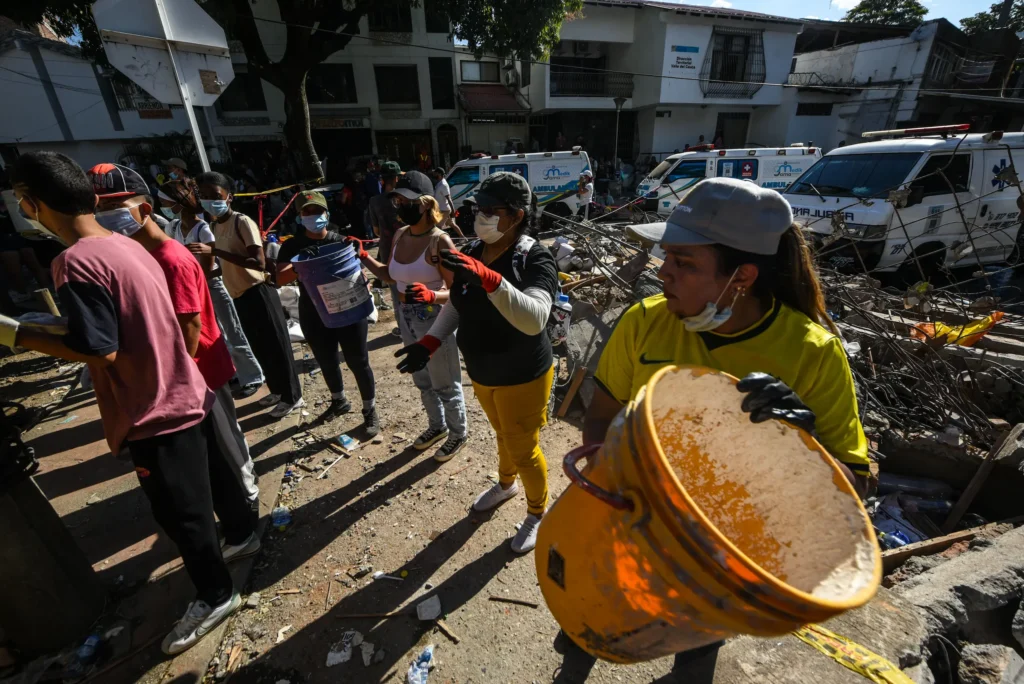 Varias mujeres ayudan a remover escombros tras el terremoto de 7.4 grados, en Carrera 39 y avenida Roosevelt en Cali, Colombia. Foto: Alejandro Meléndez